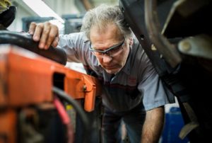 Technician checking battery on electric forklift