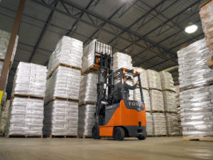 Toyota electric forklift lifting a pallet in a warehouse